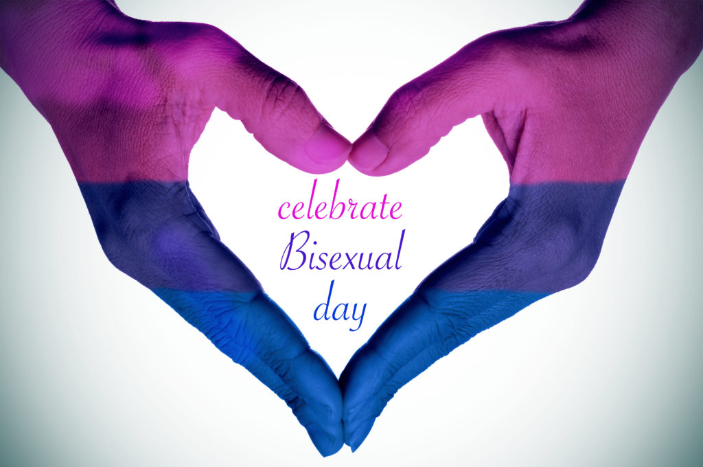 Celebrate Bisexuality Day; the hands of a young woman forming a heart patterned with the bisexual pride flag and the text celebrate bisexual day written in the center